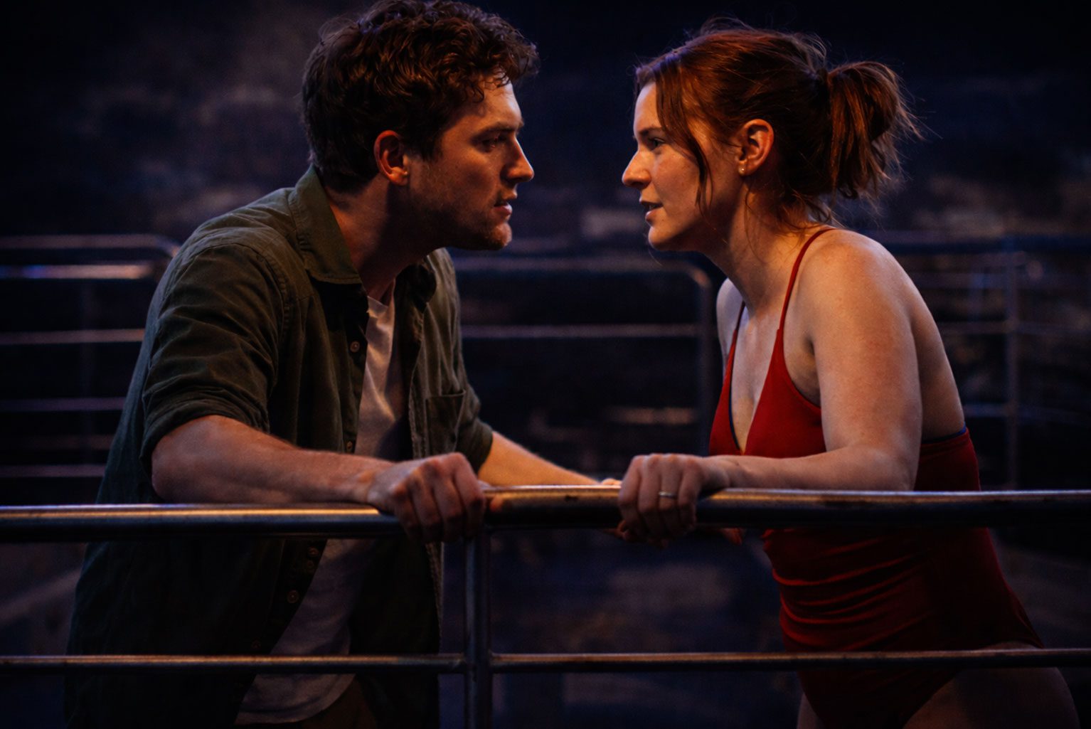 Two actors facing each other intensely on a dimly lit stage resembling a cruise setting, capturing emotional tension at Edinburgh Fringe theatre performance