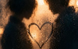 Abstract heart shape on foggy glass with blurred silhouettes representing love and uncertainty in Constellations play