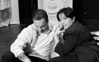 Actors lying on stage during Constellations rehearsal, sharing a quiet moment on geometric set design at Edinburgh Fringe 2026