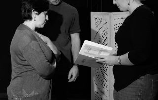 Two actors in close emotional exchange during Constellations rehearsal, showing intensity and vulnerability in black and white
