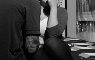 Actress reacting emotionally during rehearsal of Constellations, seated on stage with minimal set and expressive movement