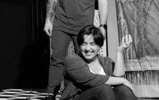 Actors performing a dramatic moment in Constellations rehearsal, physical interaction highlighting tension between characters